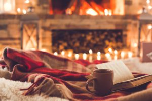 One cup and a book near the fireplace winter concept