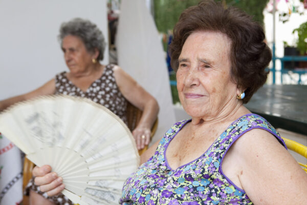 Older woman fanning herself outdoors acute care center rhode island