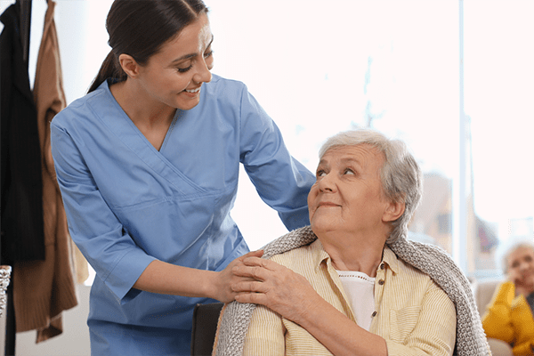 Elderly woman with healthcare worker in home nursing care